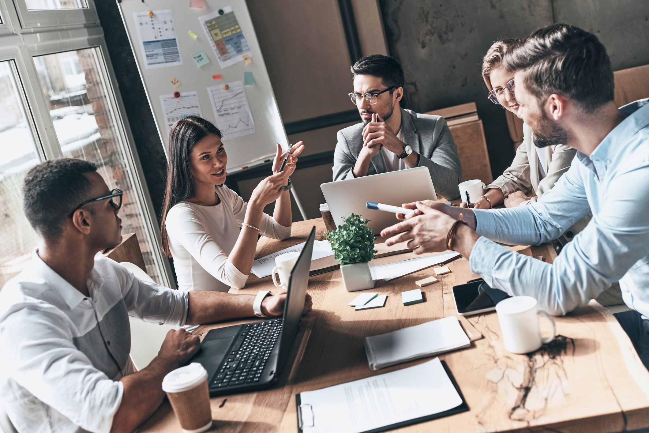 Employees looking at different leadership development opportunities within their management mentoring programs and showing it to their mentors 