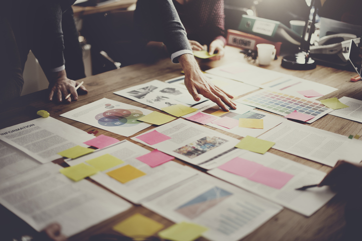 Team examining printed reports spread across a table