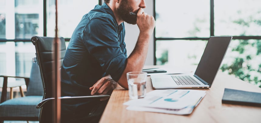 an employee sitting at a desk looking at their laptop