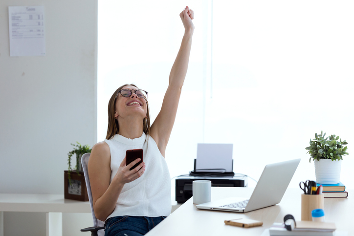 employee smiling with arm raised 