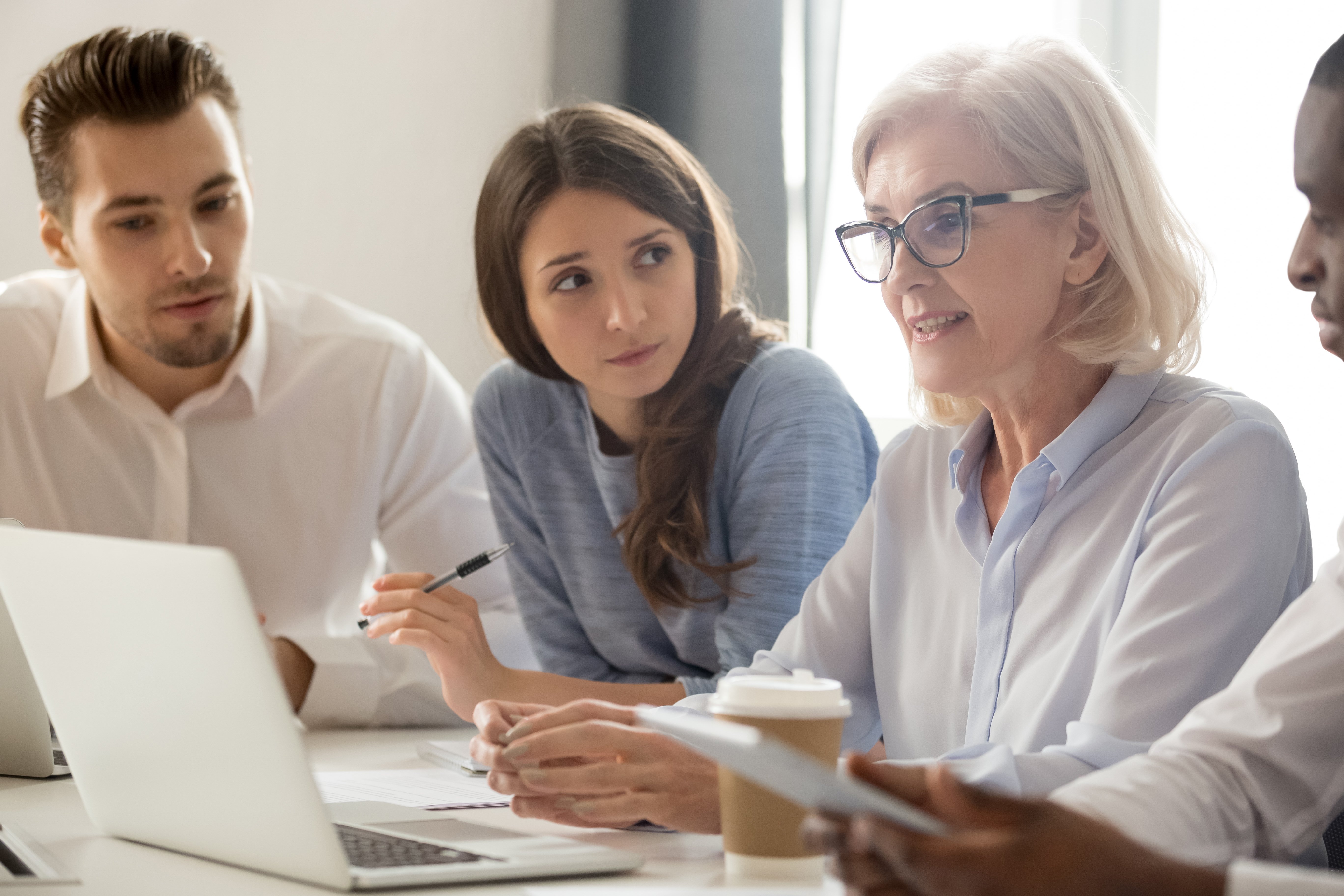 Experienced coaches showing employees who are noting down the ways they can be a better coach based on advice and tips that relate to the coaching program 